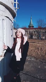 Woman using smart phone in front of building