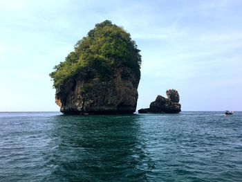 Rock formation by sea against sky