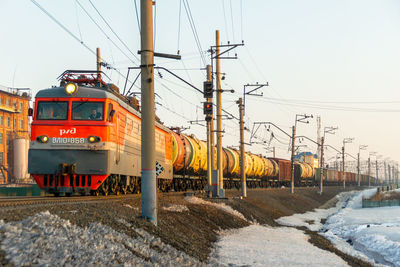 Train on railroad tracks against sky during winter