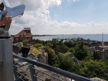 People by sea against buildings in city