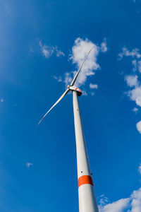 Low angle view of windmill against blue sky