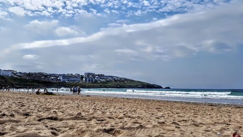 People at beach against sky