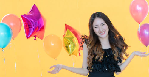 Portrait of a smiling young woman with balloons