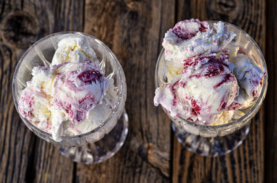 Overhead view of white chocolate marionberry swirl ice cream scoops in crystal glasses on wood