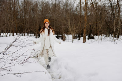 Woman standing on snow covered field