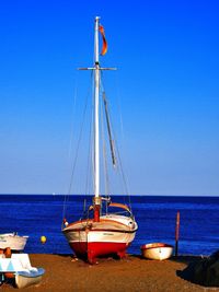 Boats in sea against blue sky