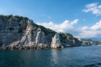 Scenic view of rocks in sea against sky