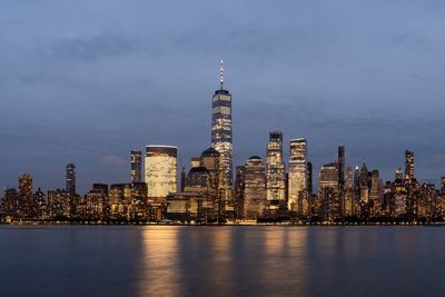 Illuminated buildings in city against sky