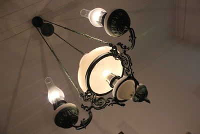 Low angle view of illuminated light bulbs hanging from ceiling