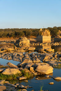 View of rocks and river against clear sky