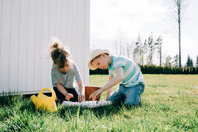 Kids planting seeds in egg shells in the garden at home outside