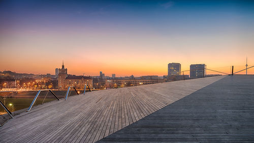 View of bridge and buildings against sky during sunset