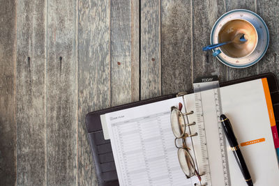 Directly above shot of books and empty coffee cup on table