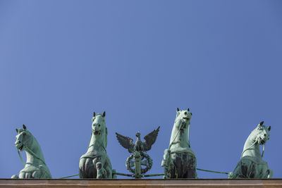 Low angle view of statue against clear blue sky