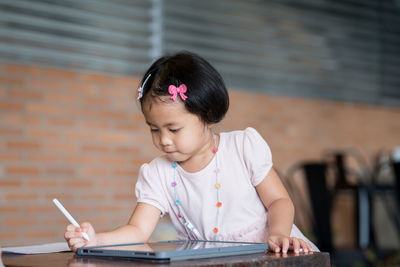 Girl looking away while sitting outdoors