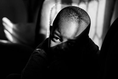 Close-up portrait of boy under light shadow