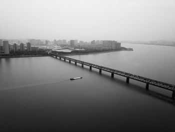 High angle view of bridge over river by buildings against sky