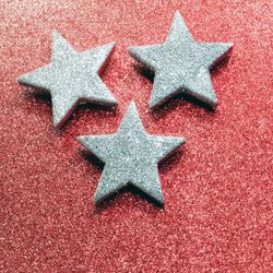 Close-up of silver star shapes on red table