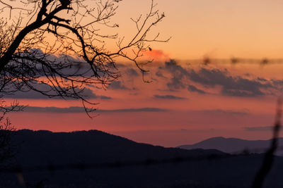 Scenic view of silhouette mountains against romantic sky at sunset