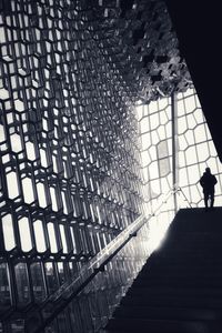 Low angle view of silhouette man walking in building