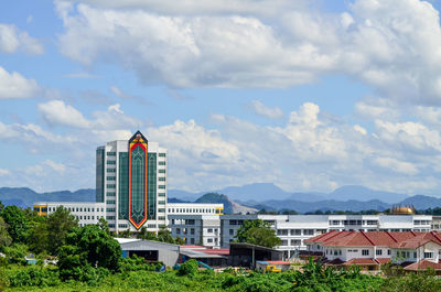 Buildings in city against cloudy sky