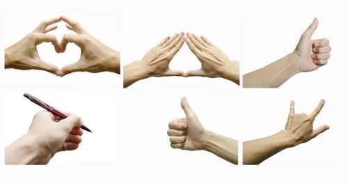 Low angle view of heart shape on hand against white background