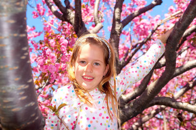 Portrait of smiling girl against tree