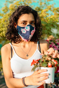 Portrait of teenage girl holding red flowering plant