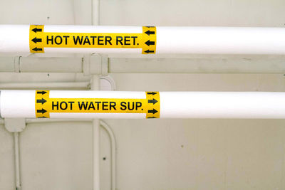 Close-up of text on water pipes at factory