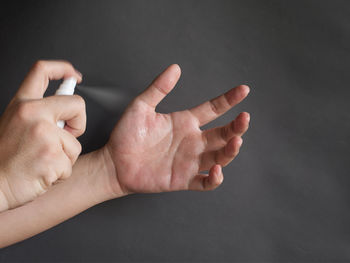 Close-up of human hand over black background