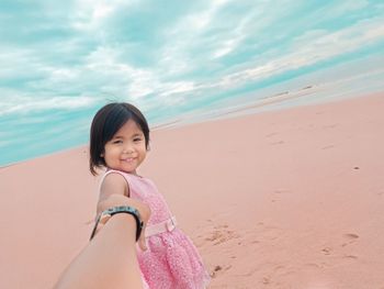 Portrait of smiling woman on beach against sky