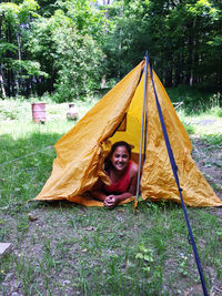 Portrait of smiling man sitting on tree