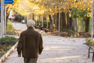 Rear view of man walking on street in city