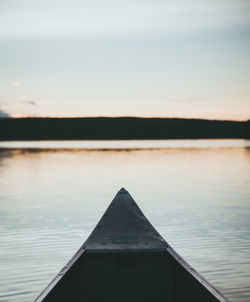 Close-up of boat in lake against sky during sunset