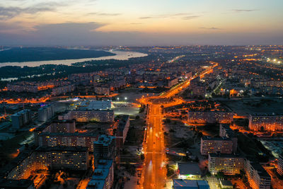 High angle view of illuminated city against sky at sunset
