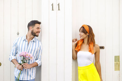 Young couple standing against wall