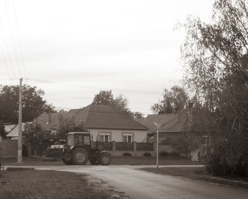 Car on road amidst buildings against sky