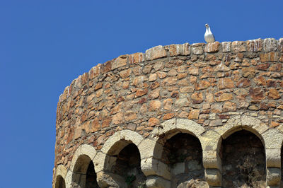 Low angle view of built structure against clear blue sky