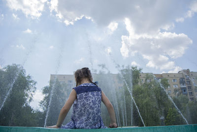 Rear view of woman standing against sky