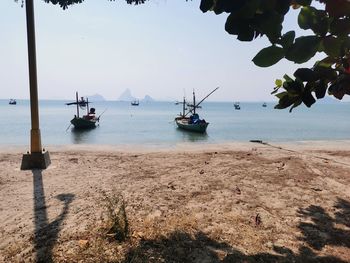 Sailboats on beach against sky