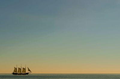 Sailboat in sea against clear sky