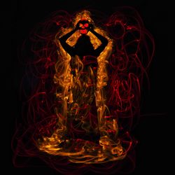 Close-up of illuminated statue against black background