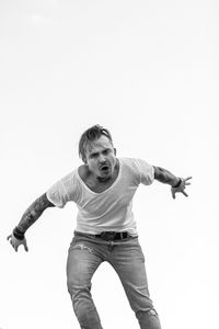 Portrait of young man standing against white background