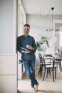 Portrait of man with laptop and coffee at home