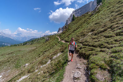 Man running on mountain against sky