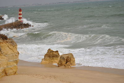 Rock formation on beach against sky