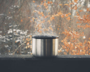 Close-up of drink on table against trees