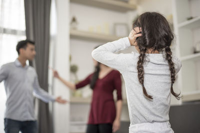 Daughter looking at parents fighting in house