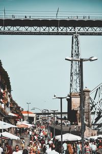 Crowd on bridge against sky in city