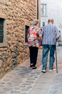 Rear view of man and woman walking outdoors